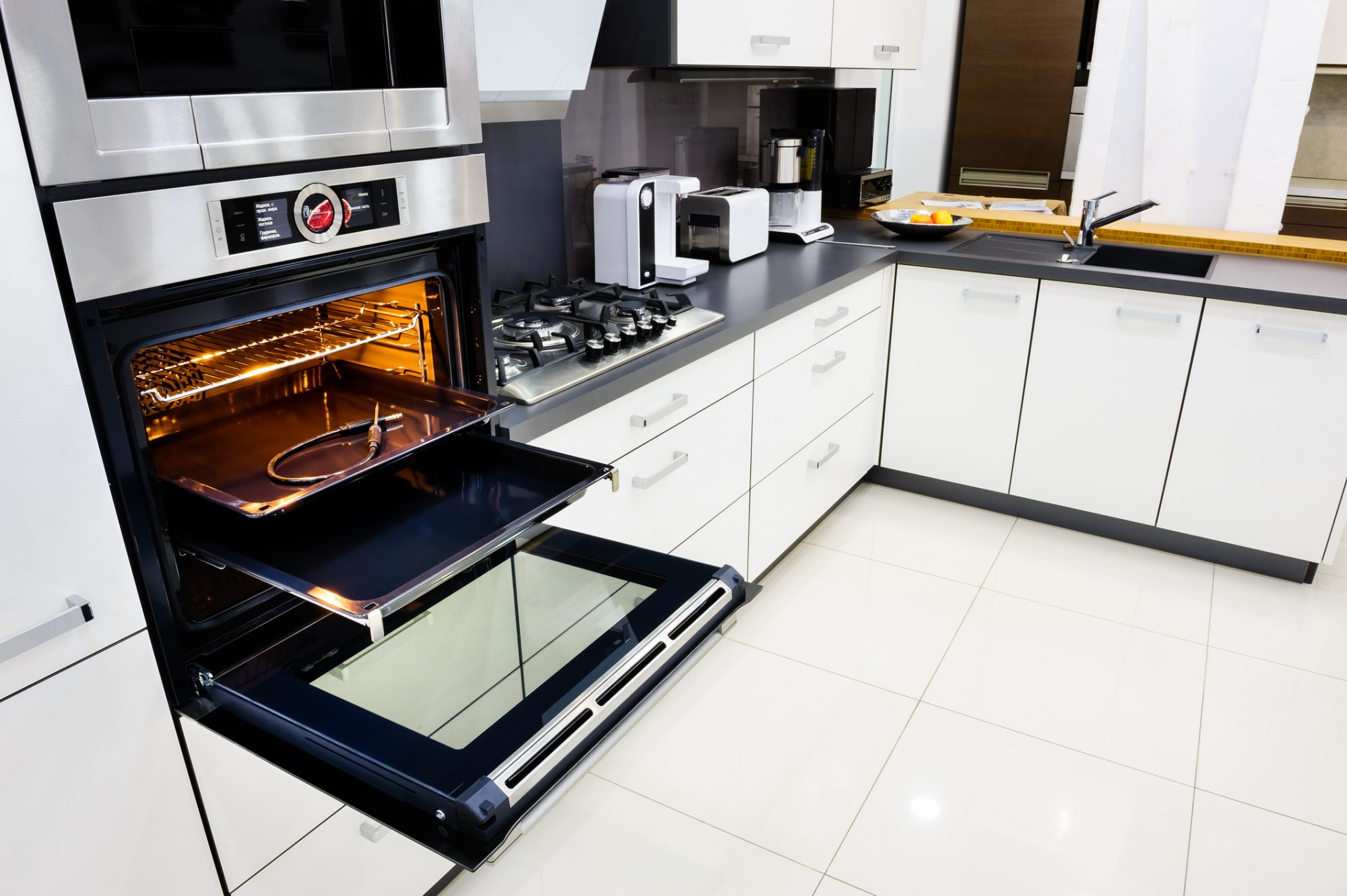 Modern luxury hi-tek black and white kitchen, clean interior design, focu at oven with open door